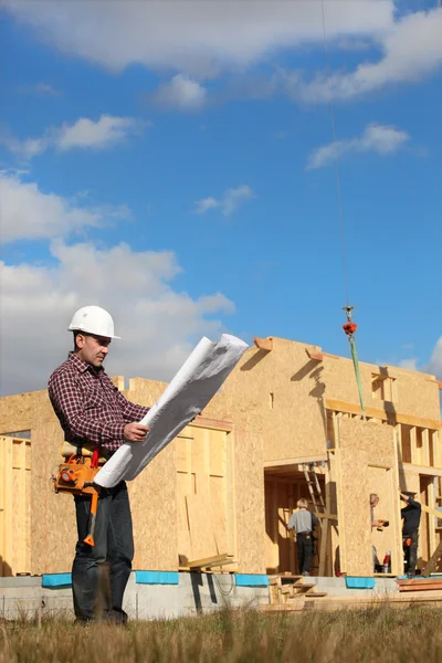 Foreman com vista para a construção de casa de madeira — Fotografia de Stock