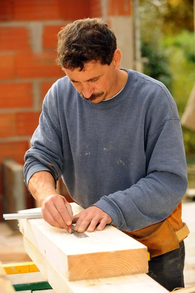 Carpintero marcando madera con lápiz —  Fotos de Stock