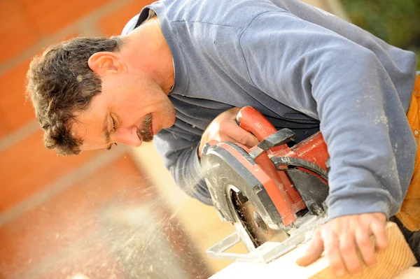 Опытный ручной рабочий с помощью циркулярной пилы — стоковое фото