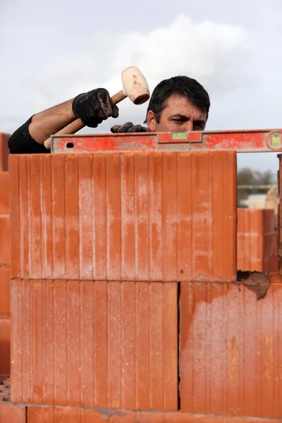 Mason adjusting brick wall — Stock Photo, Image
