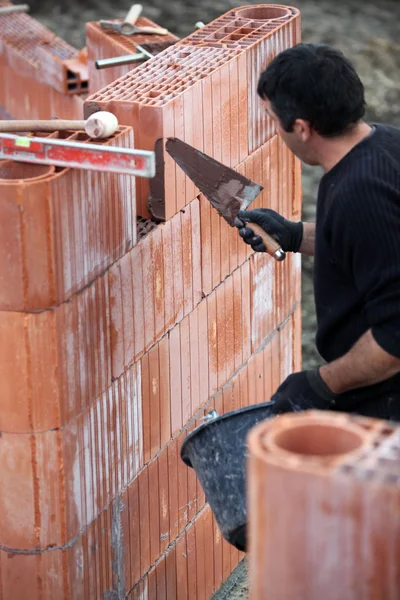 Constructor con una pared de bloque —  Fotos de Stock