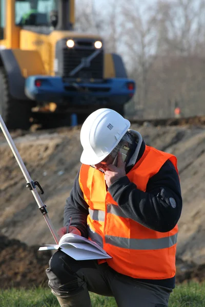 Surveyor working on construction site — Stok fotoğraf