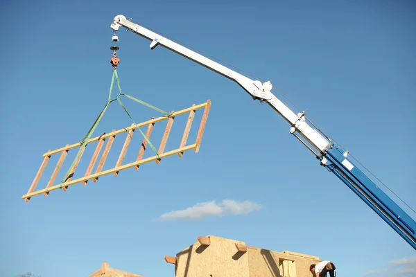 A crane lifting a wood structure. — Stock Photo, Image