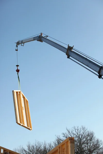 Żuraw lifing duży drewniany panel na miejsce — Zdjęcie stockowe