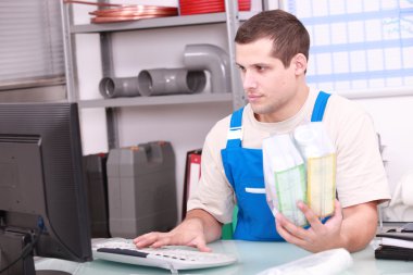 Man checking plumbing products on a computer database clipart