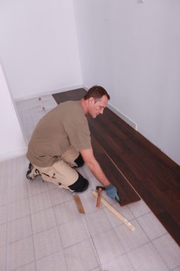 Man laying laminate flooring panels clipart