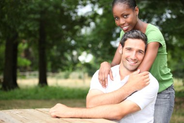 Racially mixed couple in the forest clipart