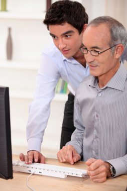 Elderly man learning computer skills clipart