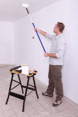 Man painting ceiling with roller clipart