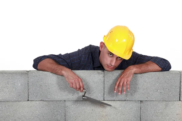 Mason encostado a uma parede de pedra — Fotografia de Stock