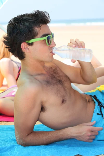Tonåring dricksvatten på stranden — Stockfoto