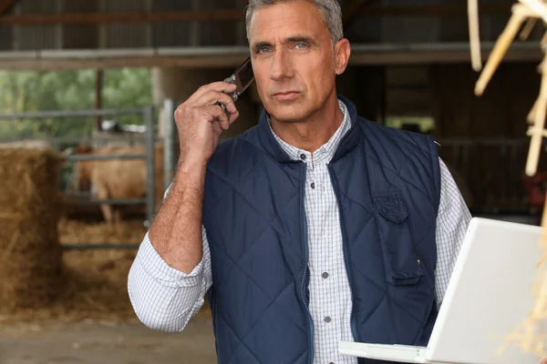 Agricultor con teléfono móvil y portátil — Foto de Stock