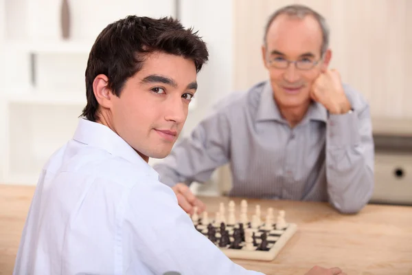 Jeune homme jouant aux échecs avec son grand-père — Photo