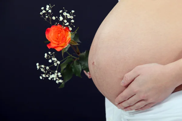 Беременная женщина с цветком . — стоковое фото