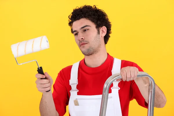 Man on step-ladder holding paint roller — Stock Photo, Image