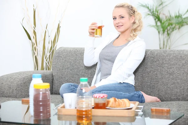 Mulher tomando café da manhã em sua sala de estar — Fotografia de Stock