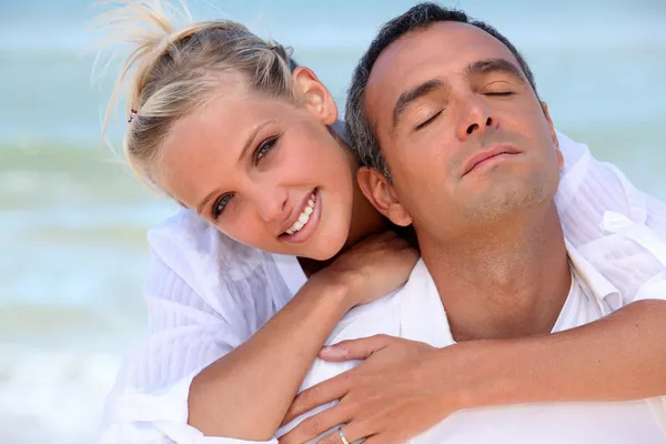Verliefde paar knuffelen op het strand — Stockfoto