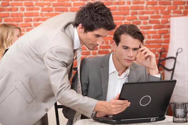 Jeunes hommes d'affaires se connectant à un ordinateur portable — Photo