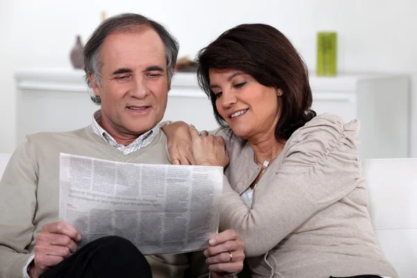 Пара, читающая газету вместе — стоковое фото
