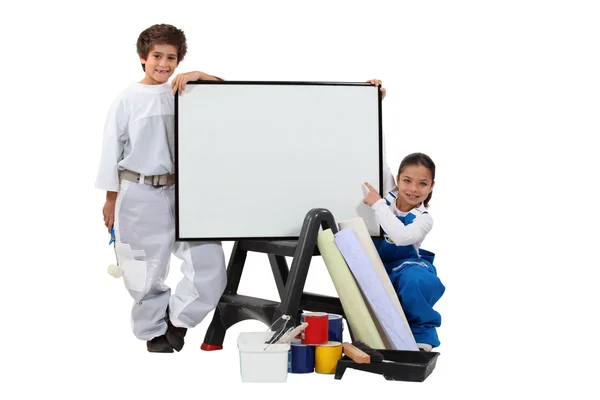 Two children dressed in housepainter and a whiteboard — Stock Photo, Image
