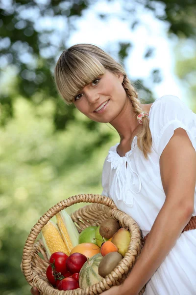 Mulher loira mostrando uma cesta de frutas — Fotografia de Stock