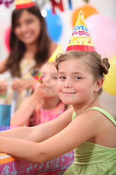 Een klein meisje en haar vrienden op een verjaardagsfeestje — Stockfoto