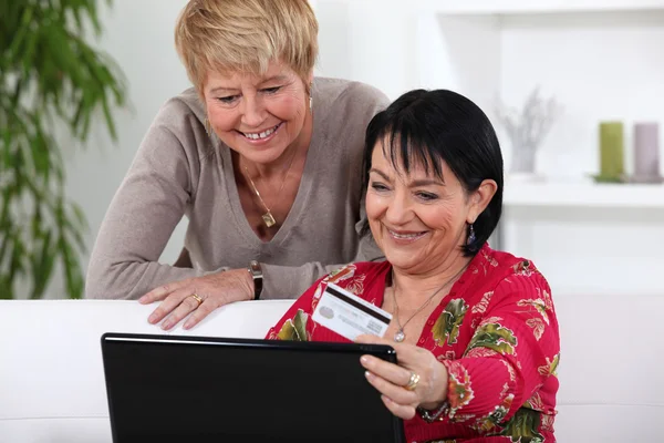 İki orta yaşlı kadınların online alışveriş. — Stok fotoğraf