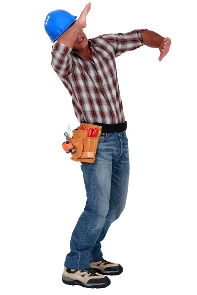 Tradesman using his arms to block a blow — Stock Photo, Image