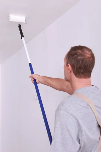 Decoratore pittura un soffitto bianco — Foto Stock