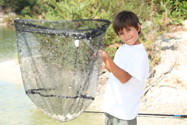 Boy with a huge fishing net — Stock Photo, Image