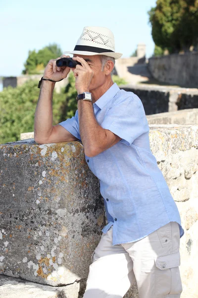 Man with binoculars and a hat — Stock Photo, Image