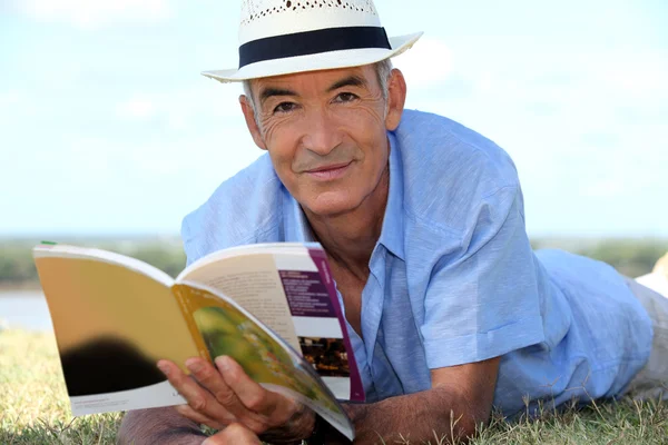 Osoby w podeszłym wieku człowiek czytając książkę poza — Zdjęcie stockowe