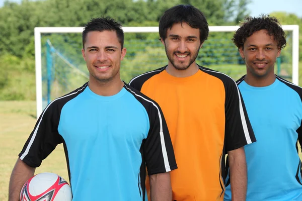 Trzech piłkarzy stojąc przed celem — Zdjęcie stockowe