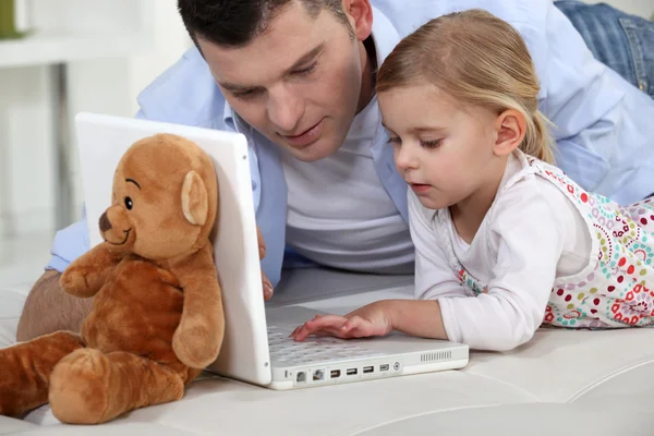 年轻的女孩和她父亲的笔记本电脑一起玩 — 图库照片