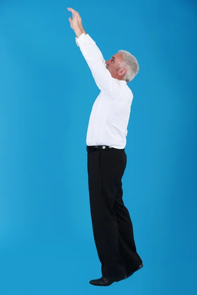 Muž s rukama nahoru na modrém pozadí — Stock fotografie