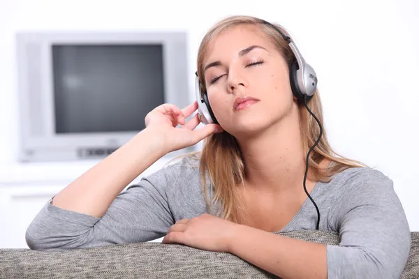 Teenage girl listening to music on headphones — Stock Photo, Image