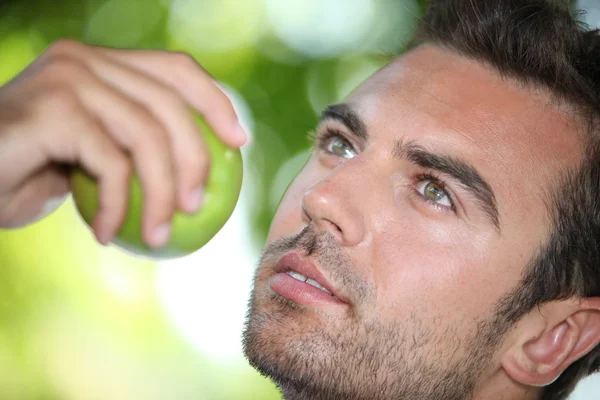 Nachdenklicher Mann isst einen Apfel — Stockfoto