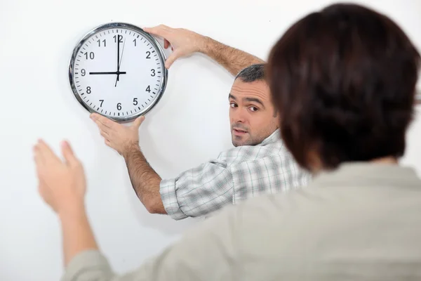 Couple straightening a crooked clock — Stock Photo, Image
