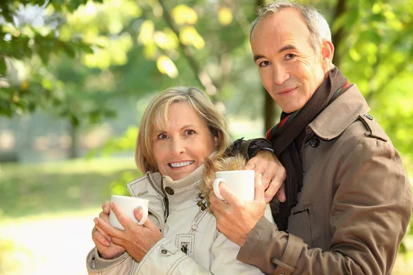 Пара середнього віку п'є каву в парку — стокове фото