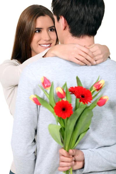 Az ember a barátnője meglepetés virágokkal — Stock Fotó