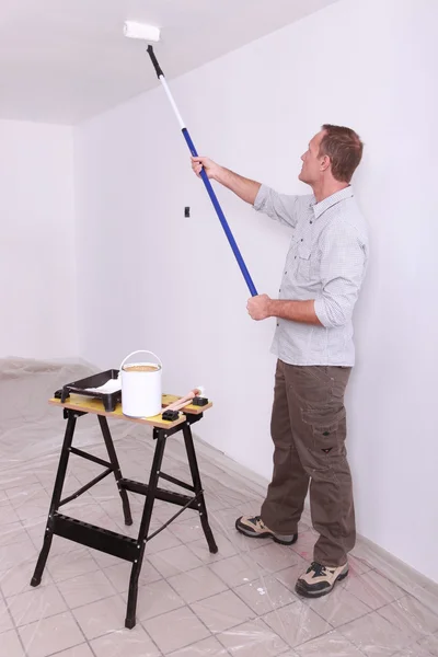 Man painting ceiling with roller — Stok fotoğraf