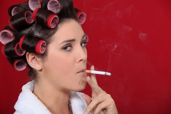 女性吸烟与她的头发在滚筒 — 图库照片