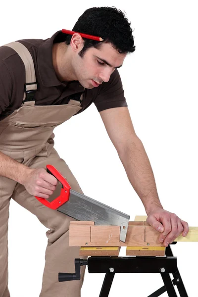 Homem cortando um pedaço de madeira — Fotografia de Stock