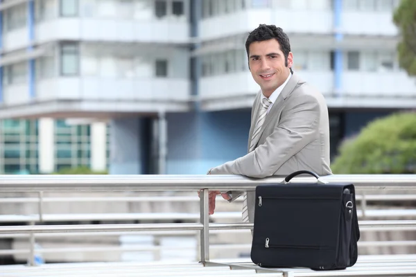 Бизнесмен с портфелем, стоящим в городской среде — стоковое фото