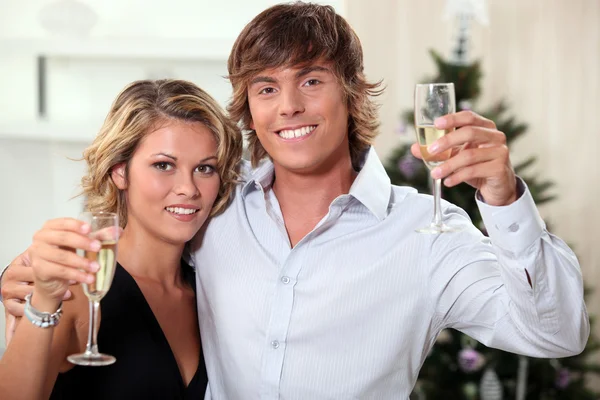 Casal jovem celebrando o Natal com champanhe — Fotografia de Stock