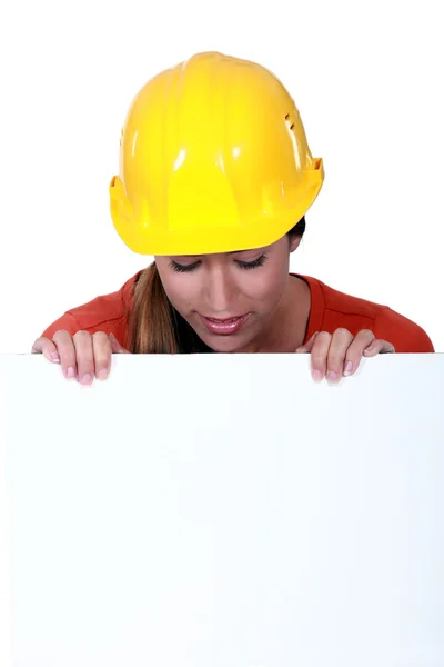 Mulher trabalhadora manual olhando para o cartaz em branco — Fotografia de Stock