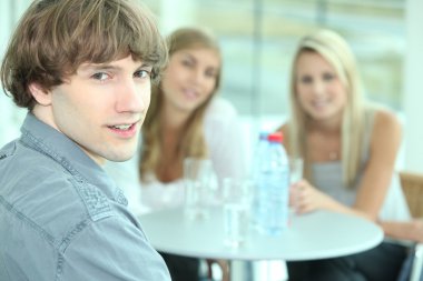 Teenager sitting with his female friends clipart