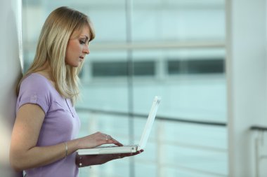 Studious woman using laptop clipart