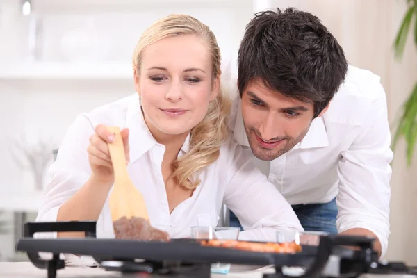 Couple cooking on a table top electric hotplate — Stock Photo, Image