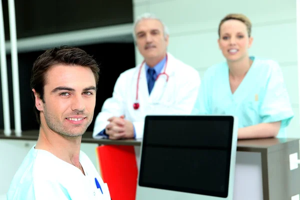医生和护士周围空白的屏幕中的计算机 — 图库照片